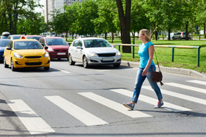 Woman crossing street at pedestrian crossing