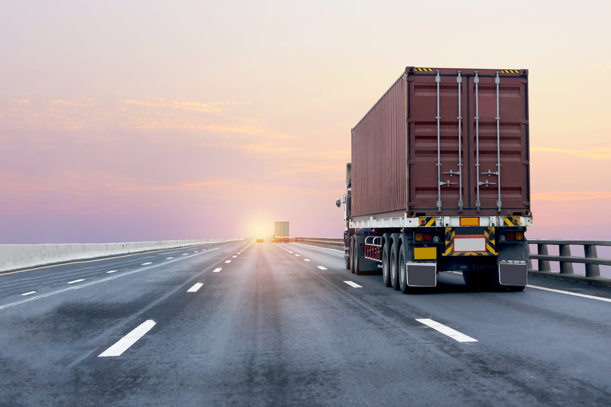 Truck on highway road with red container, transportation concept.,import,export logistic industrial Transporting Land transport on the asphalt expressway with sunrise sky