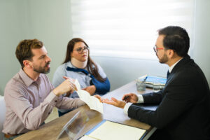 Clients discussing accident claim with lawyer in office